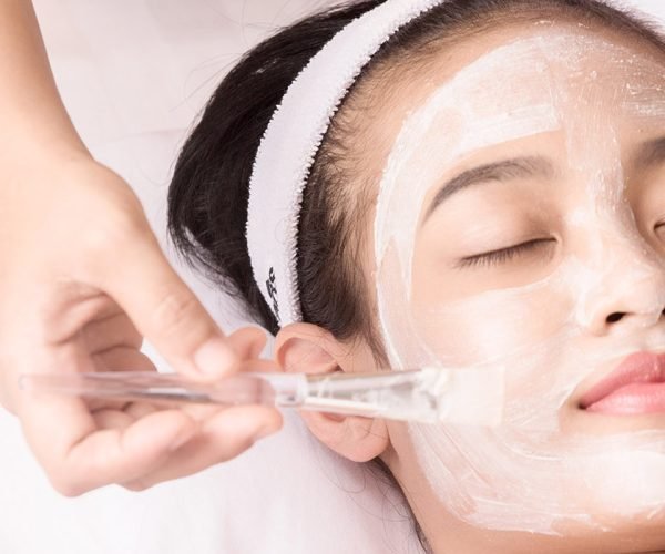 Young girl with facial mask at beauty salon